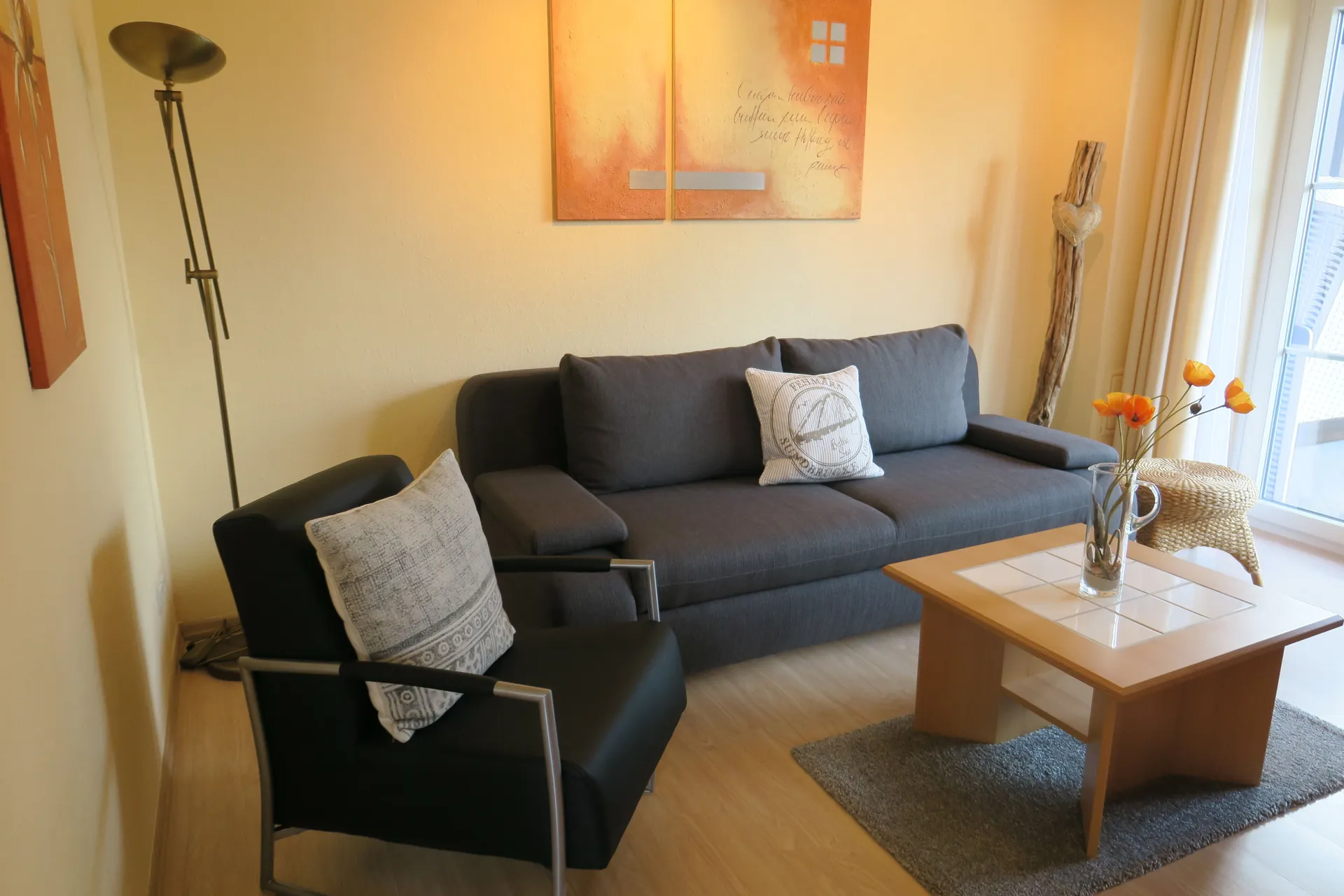 Heller Wohnbereich mit Schlafcouch und Sessel